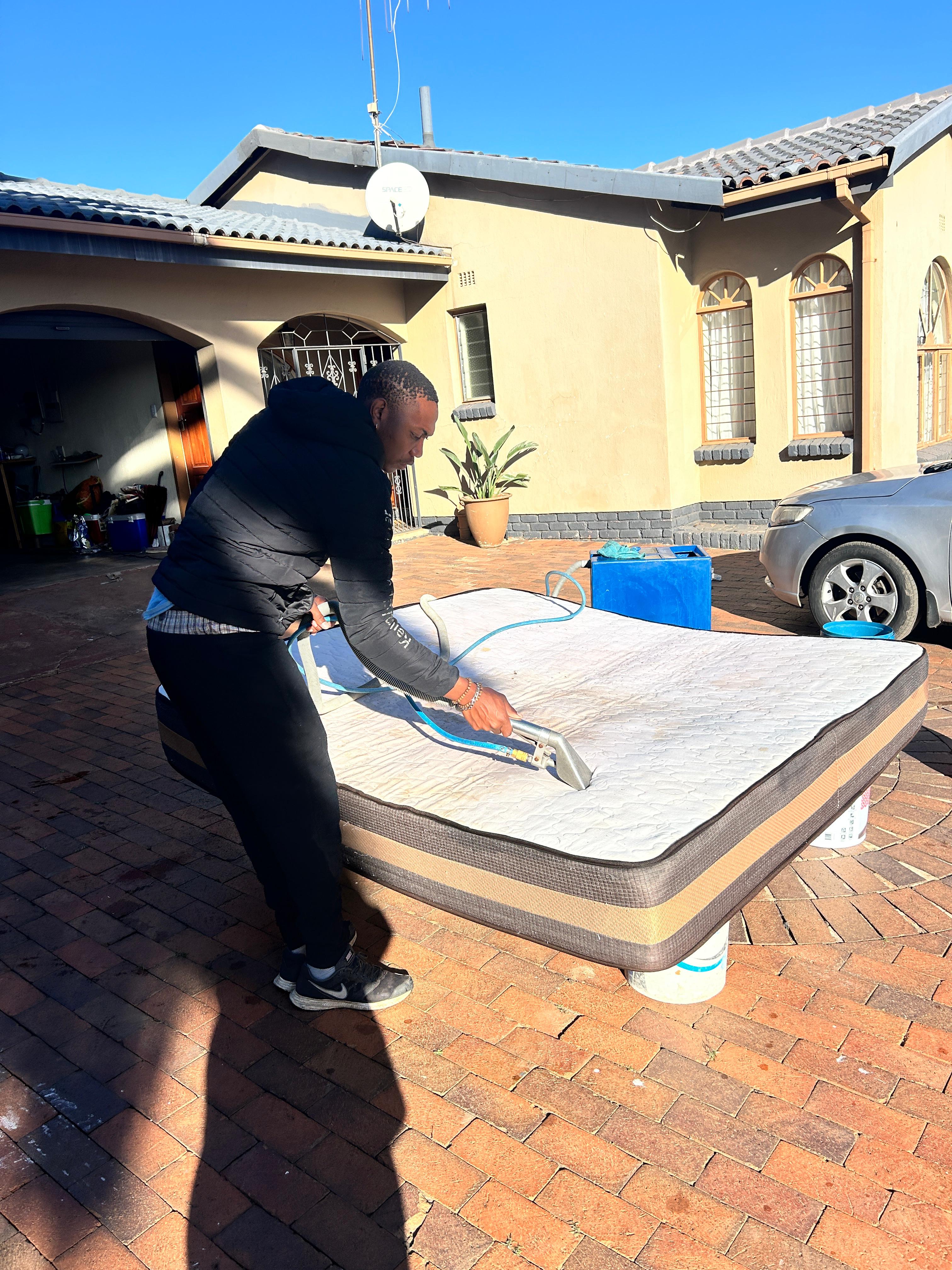 Technician using extractor on mattress